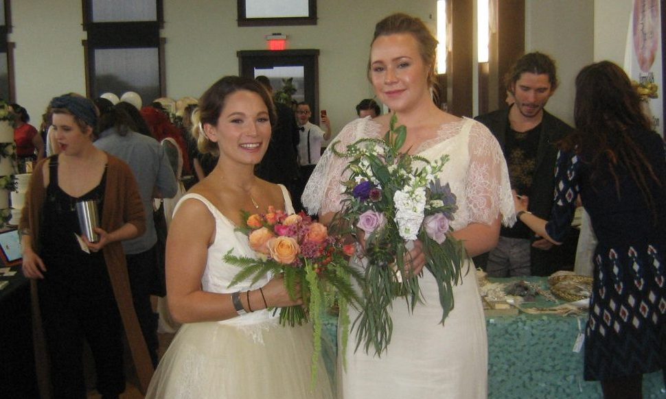 Brittany Heller (left) and Kristen Clifton model wedding dresses and bouquets at the Cannabis Wedding Expo in suburban Denver. (Bruce Kennedy, The Cannabist)