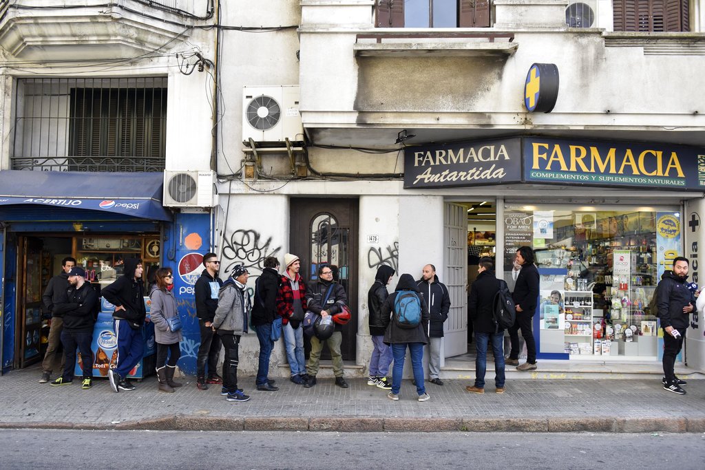 People line up outside a pharmacy selling legal marijuana in downtown Montevideo, Uruguay, Wednesday, July 19, 2017. Marijuana is going on sale at 16 pharmacies in Uruguay, the final step in applying a 2013 law that made the South American nation the first to legalize a pot market covering the entire chain from plants to purchase. (Matilde Campodonico, The Associated Press)