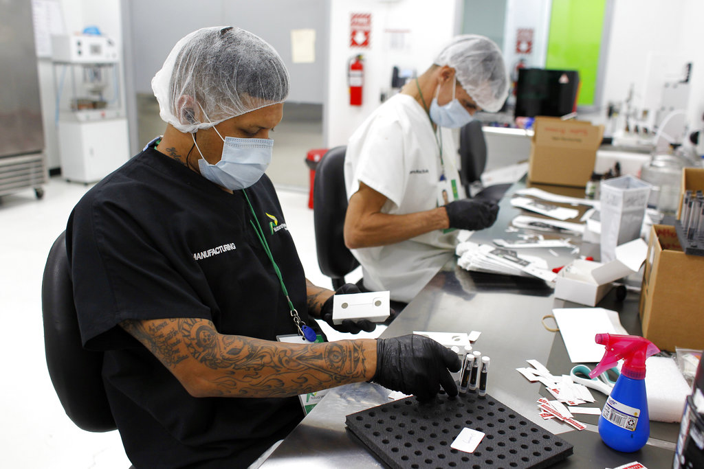 In this Monday, July 24, 2017 photo, two Natural Ventures production workers pack cannabis products in Caguas, Puerto Rico. (Ricardo Arduengo, The Associated Press)